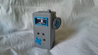 Nahaufnahme des fertigen Pocket-Knight-Geräts mit OLED-Display, blauen Tasten und Schlüsselanhänger